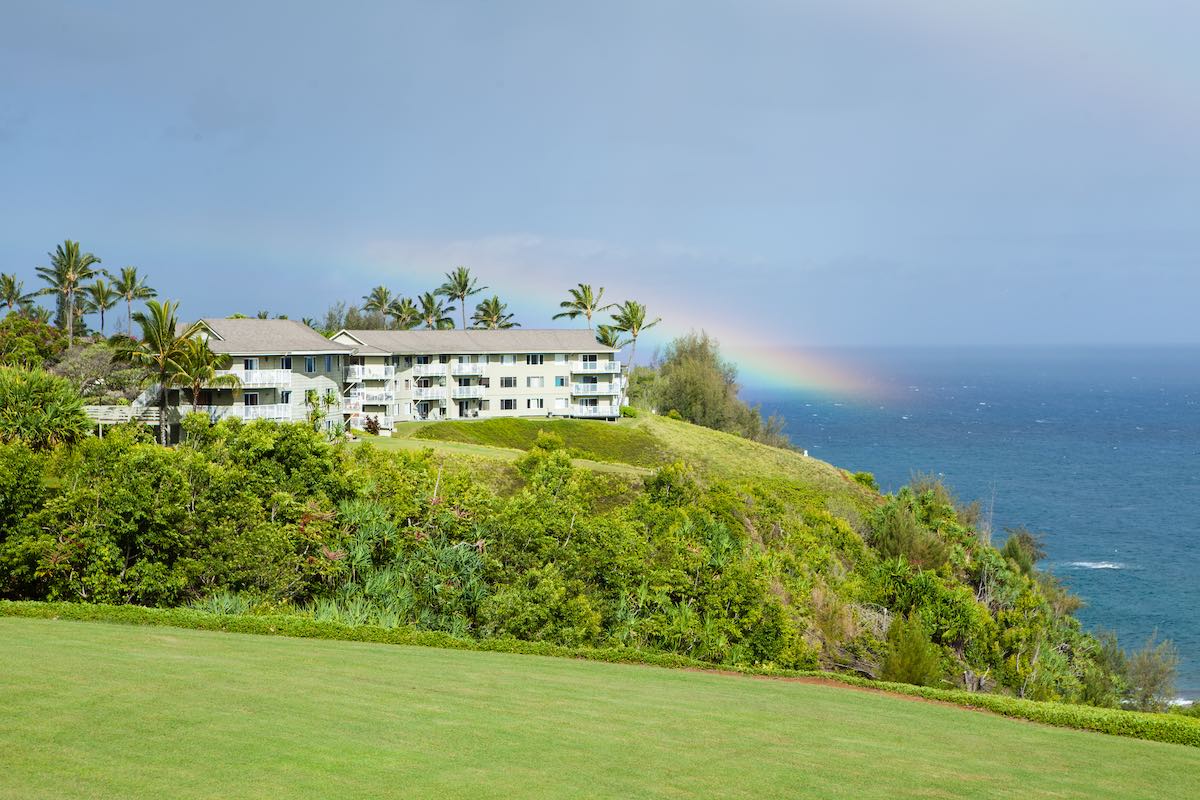 Find out the best areas to stay on Kauai recommended by top Hawaii blog Hawaii Travel Guides. Image of Hawaii traquil living with a rainbow on the cliffs of Kauai
