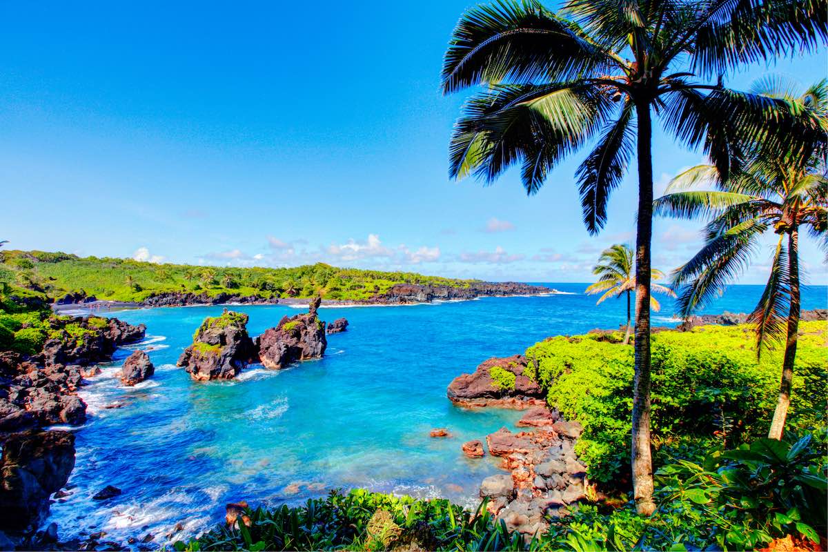 Find out these tips for visiting Hawaii for the first time recommended by top Hawaii blog Hawaii Travel Guides. Image of Waves breaking on the rocks on a sunny day during a spectacular ocean view on the Road to Hana, Maui, Hawaii, USA